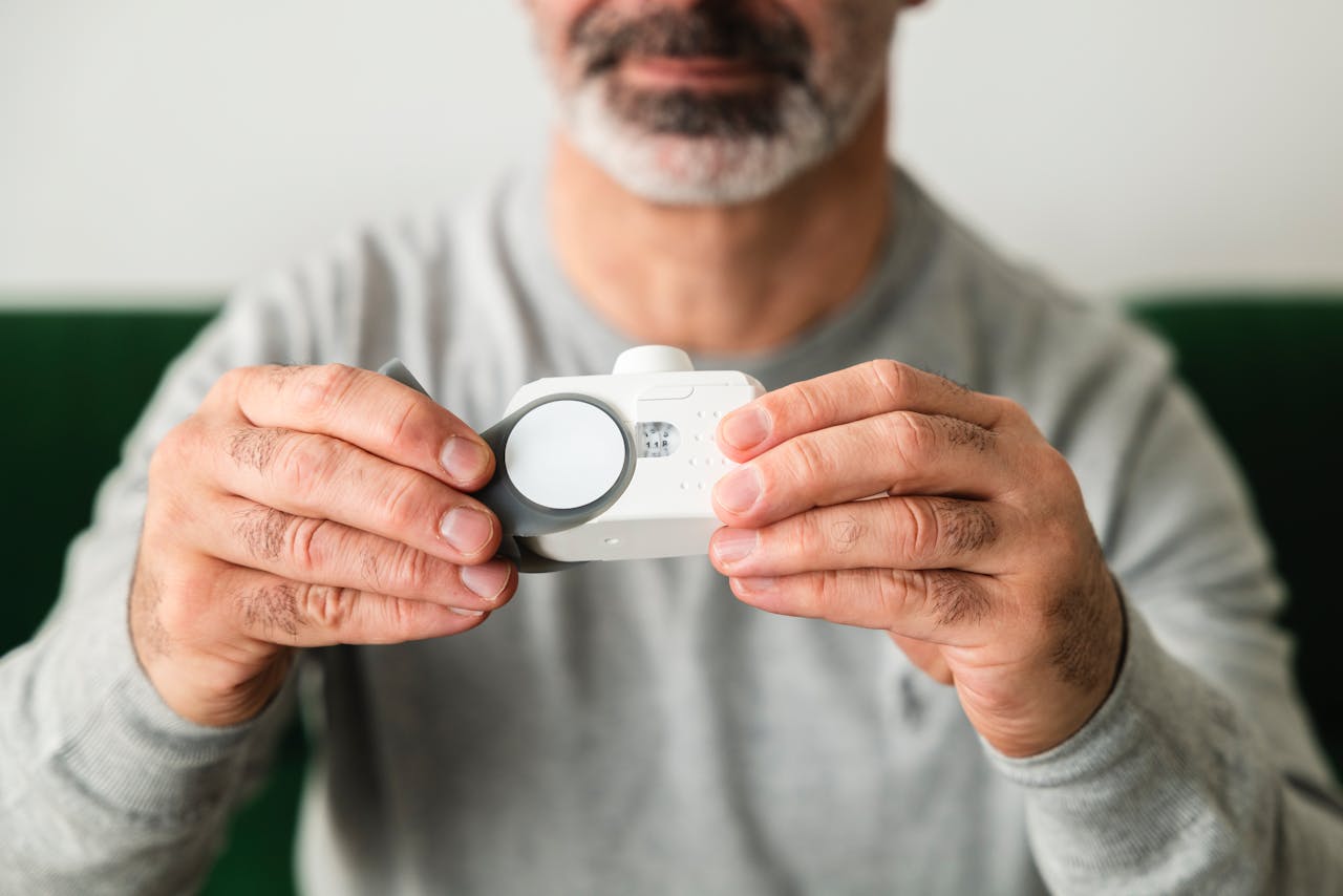 services-05 A close-up of a man using a handheld air quality analyzer, focusing on health and technology.